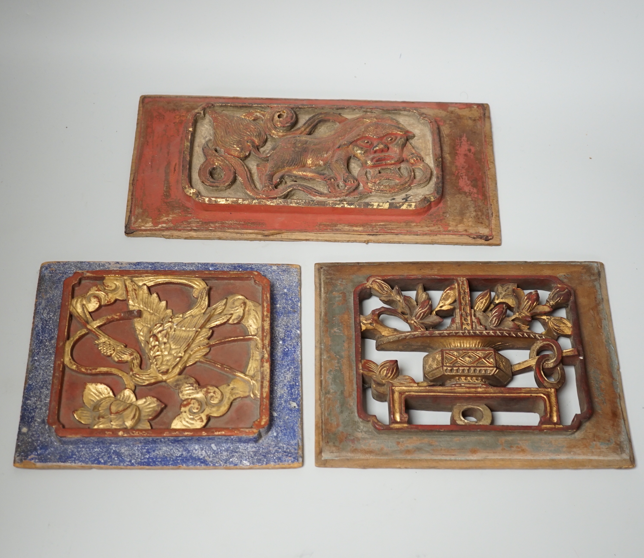 Three Chinese gilded and lacquered wood panels, early 20th century, longest 31cm